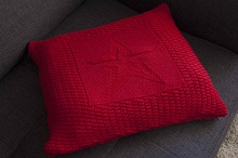 Красная подушка с вязаным рисунком